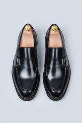 Black leather loafers with silver buckle detail for formal business wear.